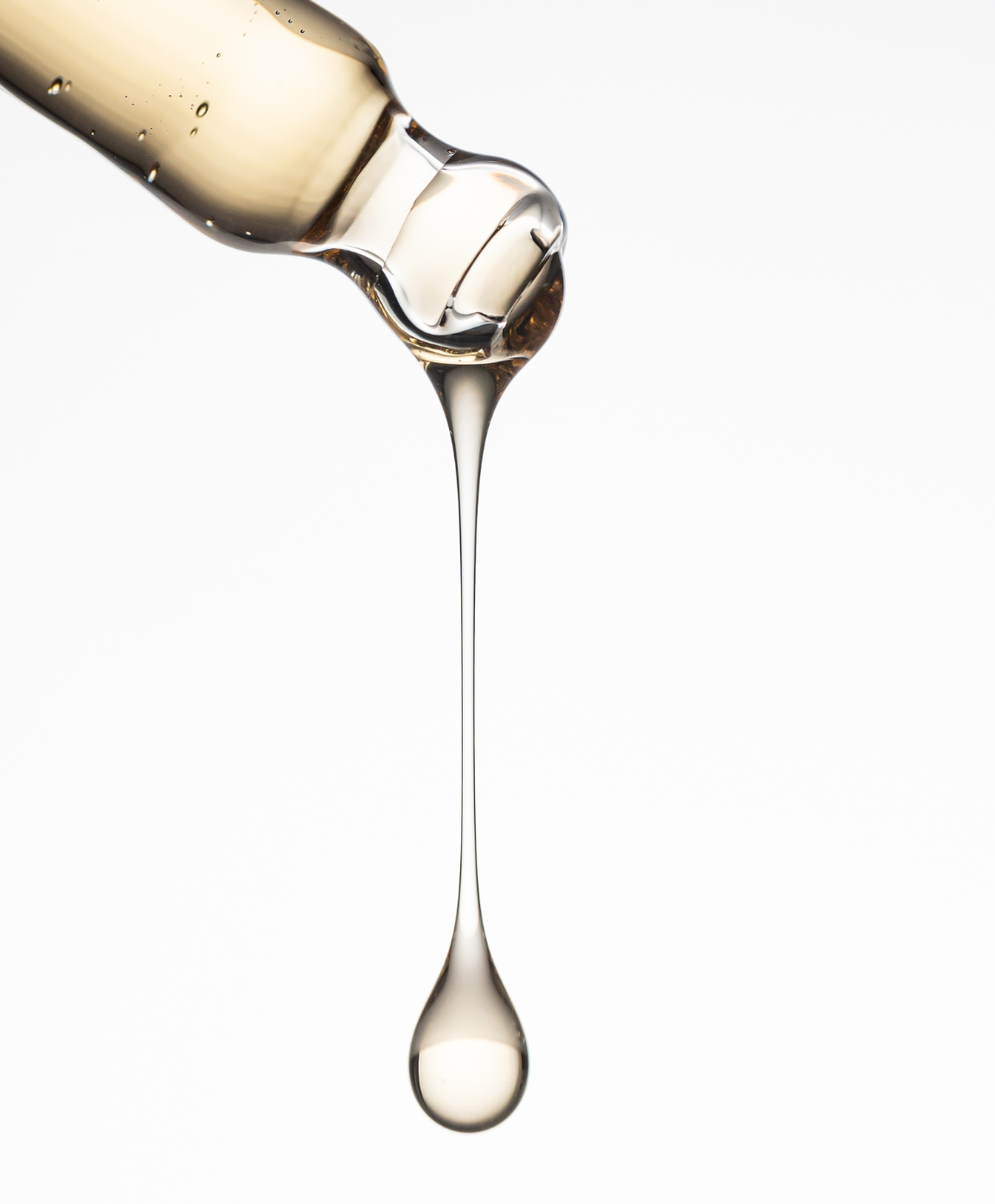 Pipette mit goldenem Serumtropfen.